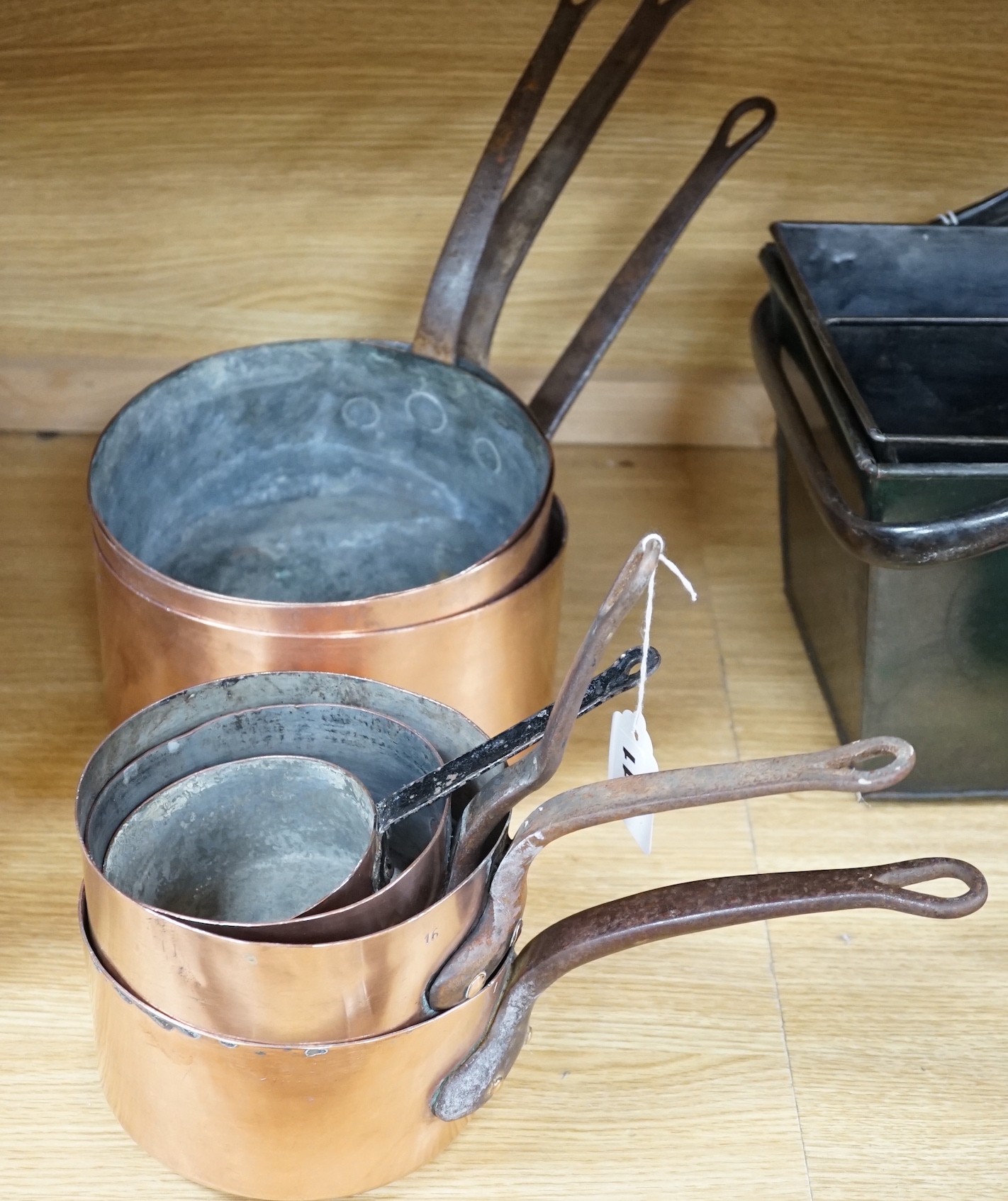 Seven graduated copper saucepans